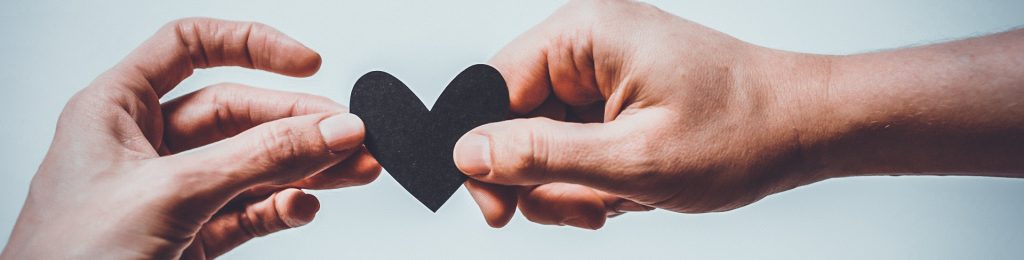 due mani che stringono un cuore.